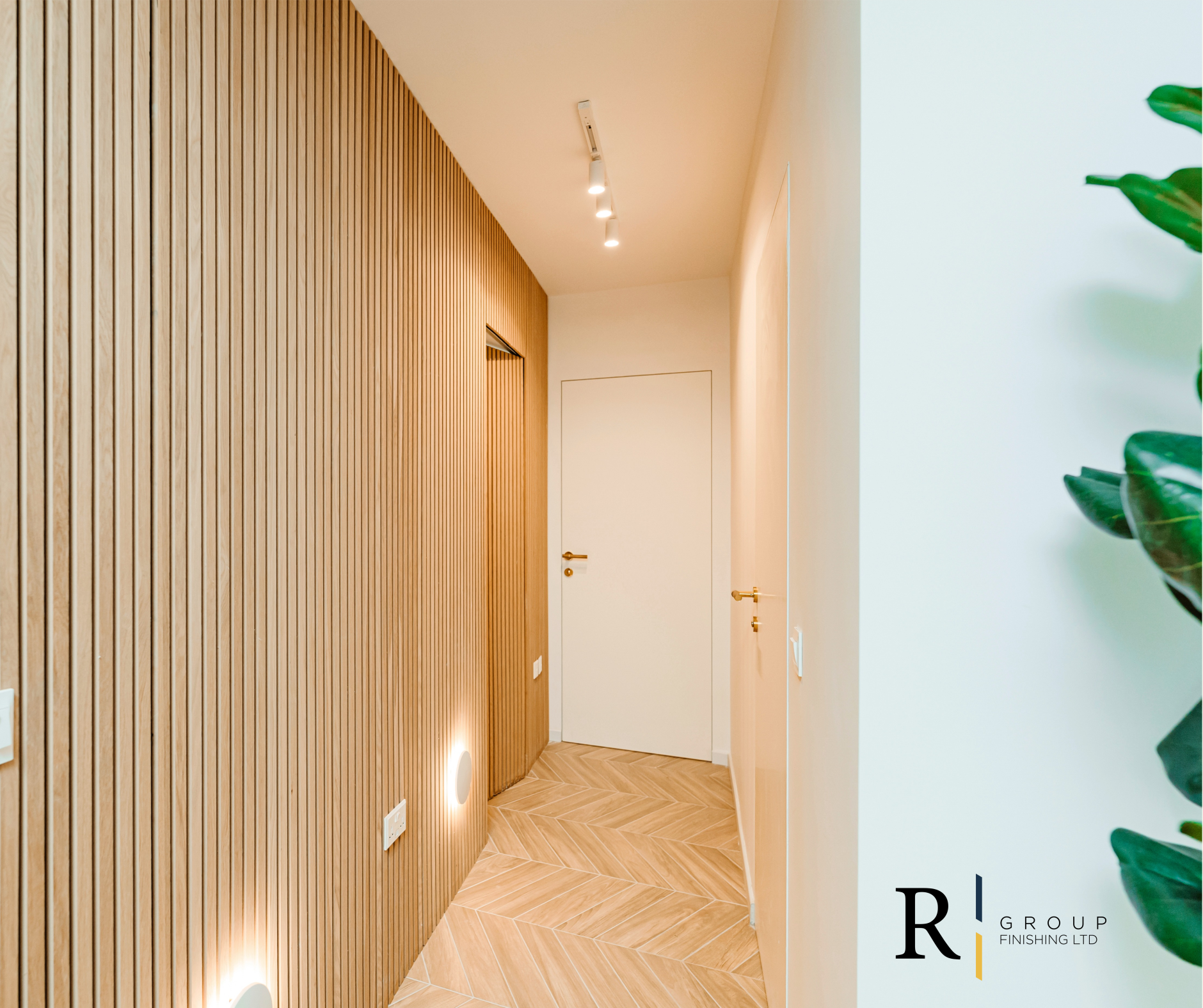 Modern hallway with oak slat wall panelling and herringbone parquet floor by R Group Finishing