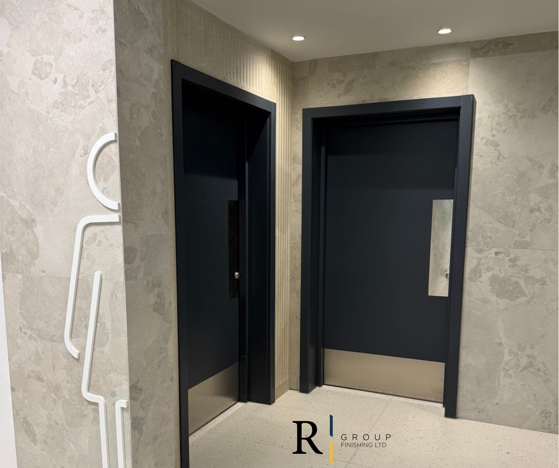 Dark charcoal doors in commercial washroom by R Group Finishing, Malta